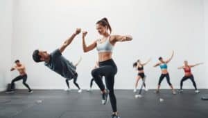 A group of athletes performing functional movement patterns in a well-lit, minimalist studio. The foreground features a man and a woman executing a series of exercises that engage the full kinetic chain, their muscles and joints working in harmony. The middle ground showcases additional individuals performing complementary movements, while the background maintains a clean, uncluttered setting with a soft, neutral color palette. The lighting is natural and diffused, highlighting the fluid, efficient motions of the subjects. The camera angle captures the movements from a slightly elevated perspective, emphasizing the interconnected nature of the kinetic chain principles.