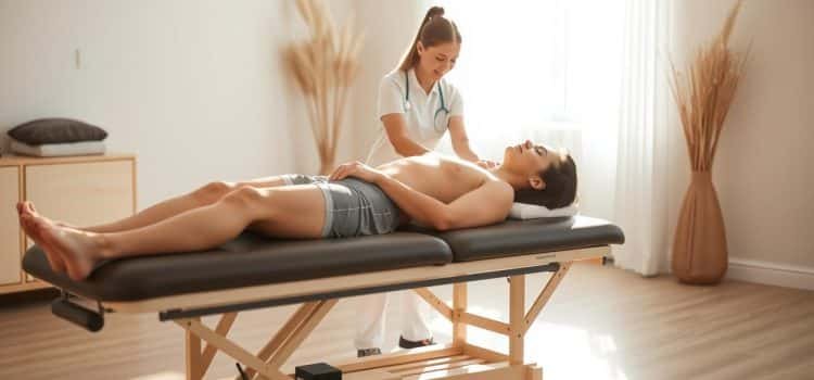 A tranquil sports therapy session, bathed in warm, natural lighting. In the foreground, a patient reclines on a padded treatment table, their body language conveying a sense of relaxation and relief. The middle ground features a physiotherapist carefully guiding the patient through gentle stretches and exercises, their movements fluid and purposeful. The background showcases a serene, minimalist space, with clean white walls and accents of earthy tones, creating a calming, therapeutic ambiance. The overall scene radiates a feeling of progress, healing, and the positive outcomes of a dedicated sports therapy regimen.